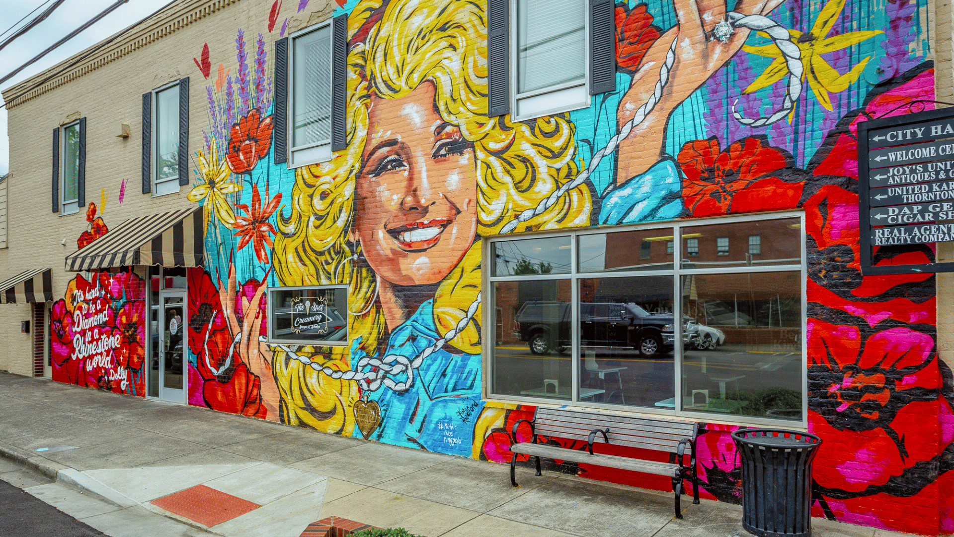 Photo of the Dolly Parton mural in downtown Ringgold, GA. Young Dolly Parton face with blond curled hair wither her famous quote it's hard to be pearls in a rhinestone world.