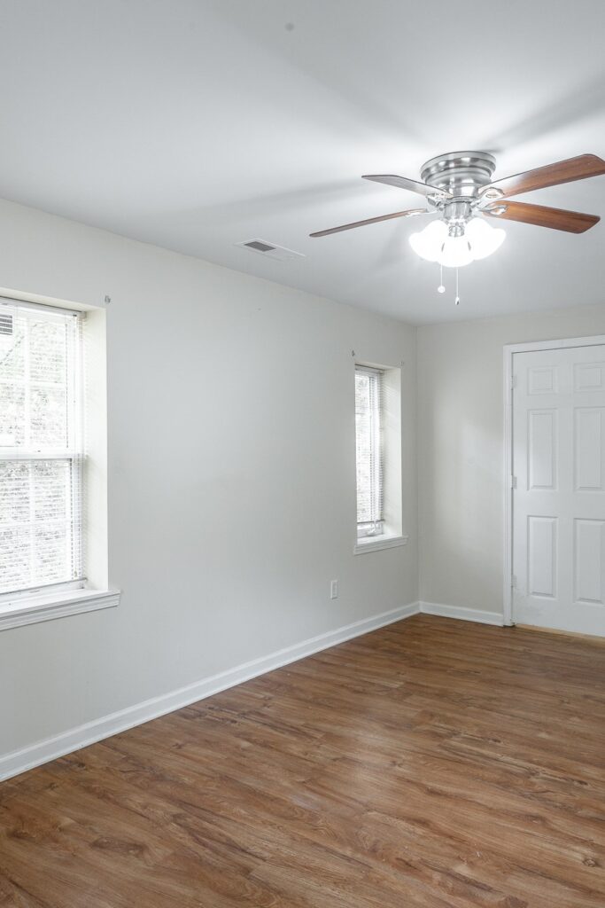 Living room of 2711 Banks road with hardwood floors, ceiling fan and white walls.