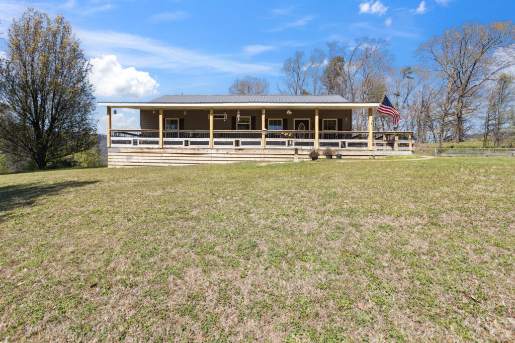 Frontof 133 Ridge Road 1 story 2 bedroom 2 bathroom home for sale with front porch across the front.