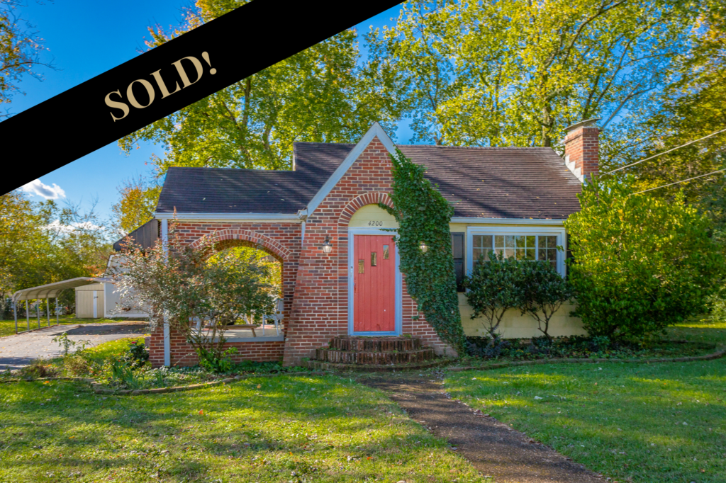 sold Front of 4200 Ealy Rd a charming 1 story brick facade home with red door and side porch