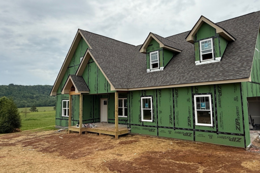 Picture of a spec homes in production 2 story home with roof on but not siding.