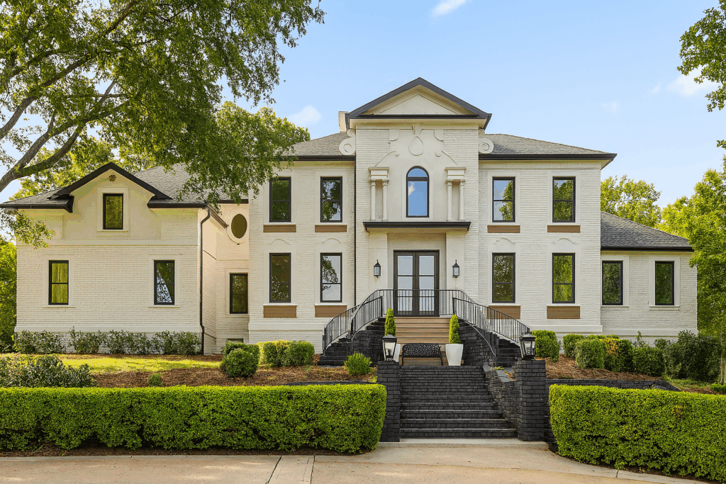 The front of 1103 Drive a cream wash brick two story home with black and beige accents. Luxurious home for sale in Chattanooga