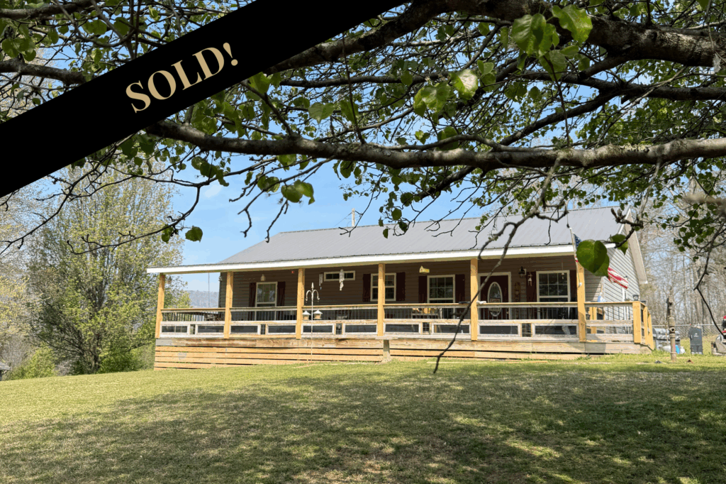 Frontof 133 Ridge Road 1 story 2 bedroom 2 bathroom home for sale with front porch across the front.