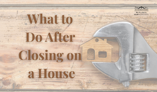 Feature image for the article What to Do After Closing on a House. Background is rough hewn piece of wood with wrench holding a piece of wood cut to a 2d house.
